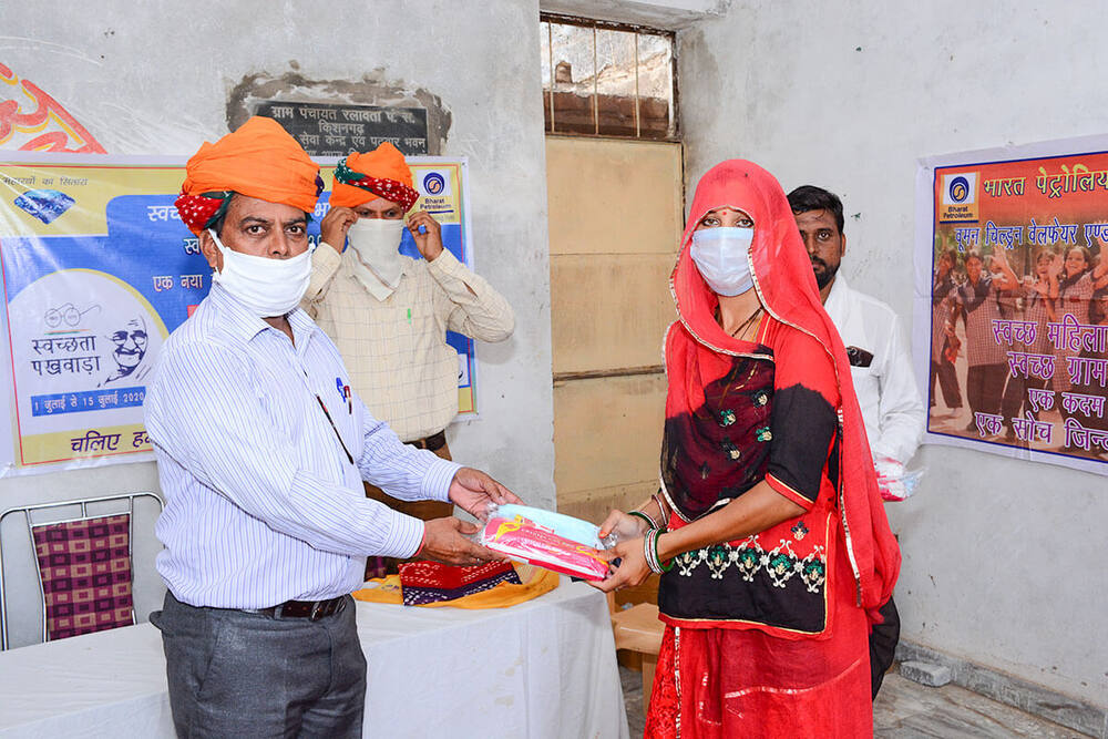 BPCL Swachhata Pakhwada mask and sanitary-kit distribution at a doorway, Ralawata