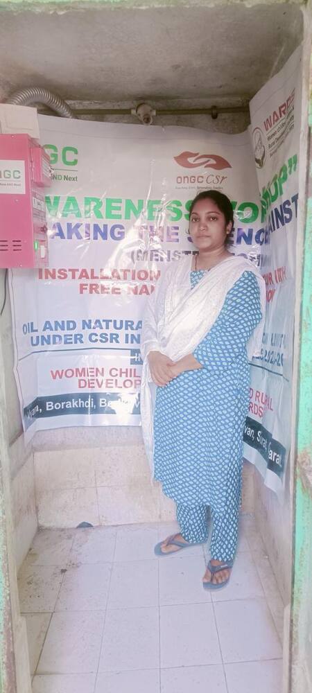 Student beside the installed incinerator unit, Vyara, Gujarat