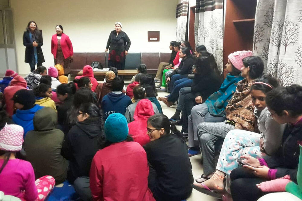 Staff addressing the same seated group, informal hostel session