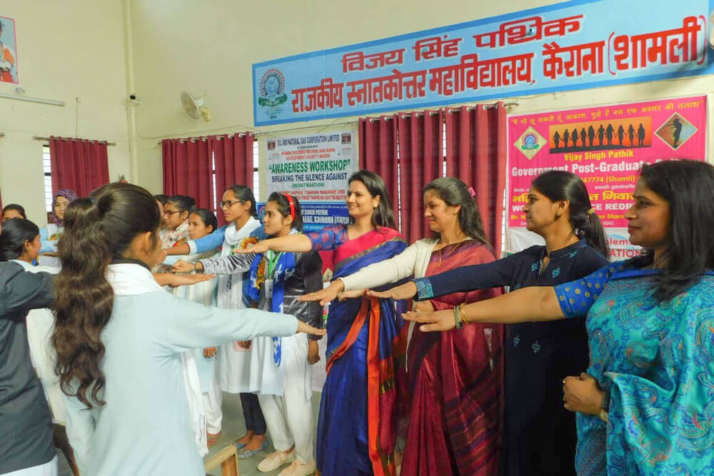 Students and WARDS staff in a hand-chain line, ONGC-WARDS banner, Kairana