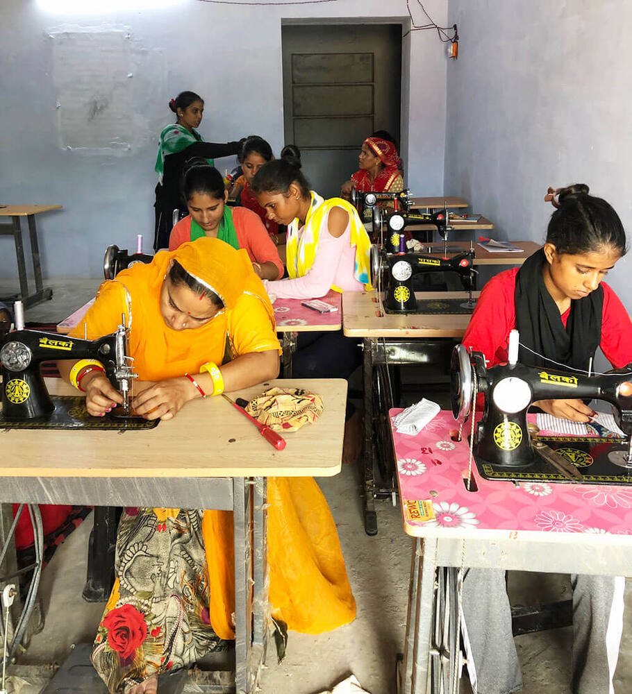Women's tailoring class in session, multiple sewing machines, RITES-funded training