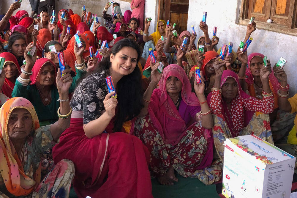 Dr. Shweta Laddha distributing toothpaste to a large crowd of village women, Ralawata