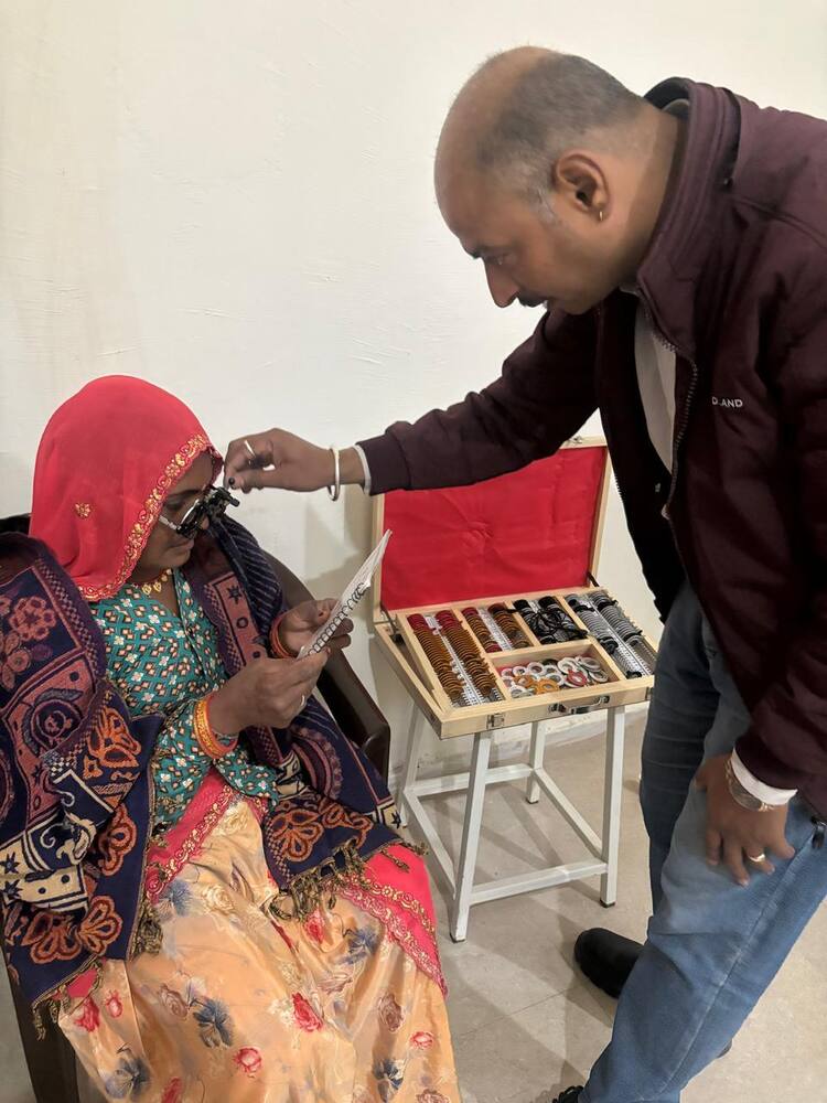 Optician fitting trial spectacles for a patient