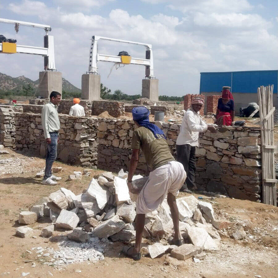 Masons building the Common Facility Centre's boundary wall, Ralawata